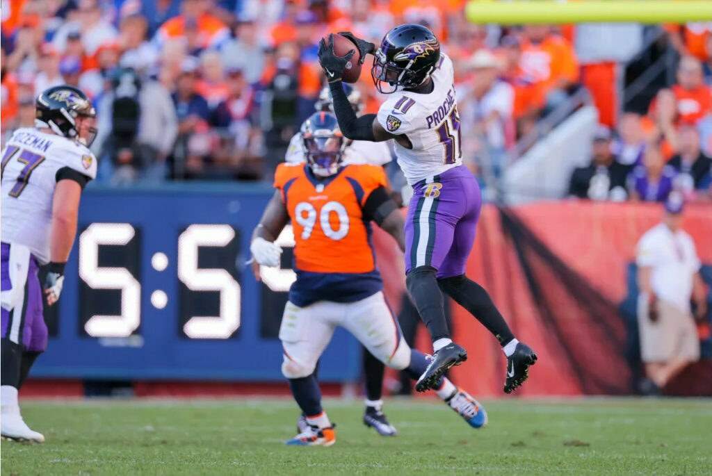 James Proche, wide receiver do Balimore Ravens, recepcionando passe contra o Denver Broncos