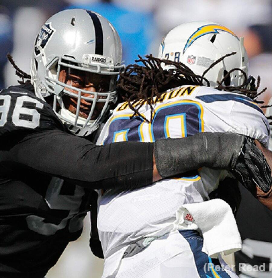 Denico Autry, defensive end do Raiders, tackleando Melvin Gordon, running back do Los Angeles Chargers