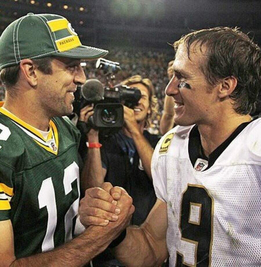 Green Bay Packers quarterback Aaron Rodgers (L) and New Orleans Saints quarterback Drew Brees (R) shake hands after their NFL football game in Green Bay, Wisconsin, September 8, 2011. The Packers won the game 42-34.    REUTERS/Jeff Haynes (UNITED STATES - Tags: SPORT FOOTBALL)