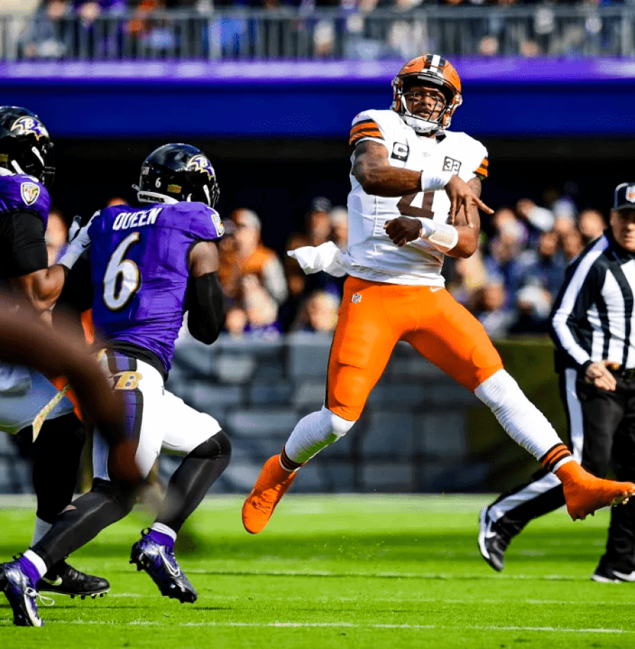 Três jogadores de roxo do Baltimore Ravens cercando o quarterback do Cleveland Browns de branco