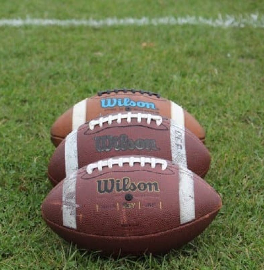 Duas bolas de futebol americano da NFL em um gramado verde. A NFL tem mostrado interesse no mercado do Brasil