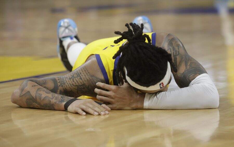 Golden State Warriors guard D'Angelo Russell remains on the floor after being injured during the second half of an NBA basketball game against the Dallas Mavericks in San Francisco, Saturday, Dec. 28, 2019. (AP Photo/Jeff Chiu)