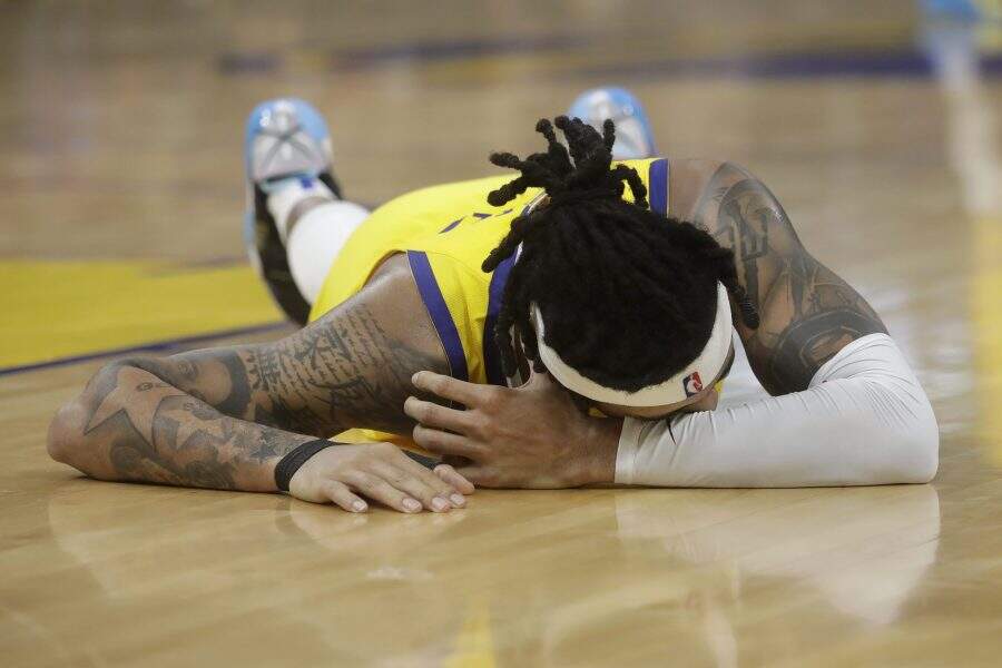 Golden State Warriors guard D'Angelo Russell remains on the floor after being injured during the second half of an NBA basketball game against the Dallas Mavericks in San Francisco, Saturday, Dec. 28, 2019. (AP Photo/Jeff Chiu)