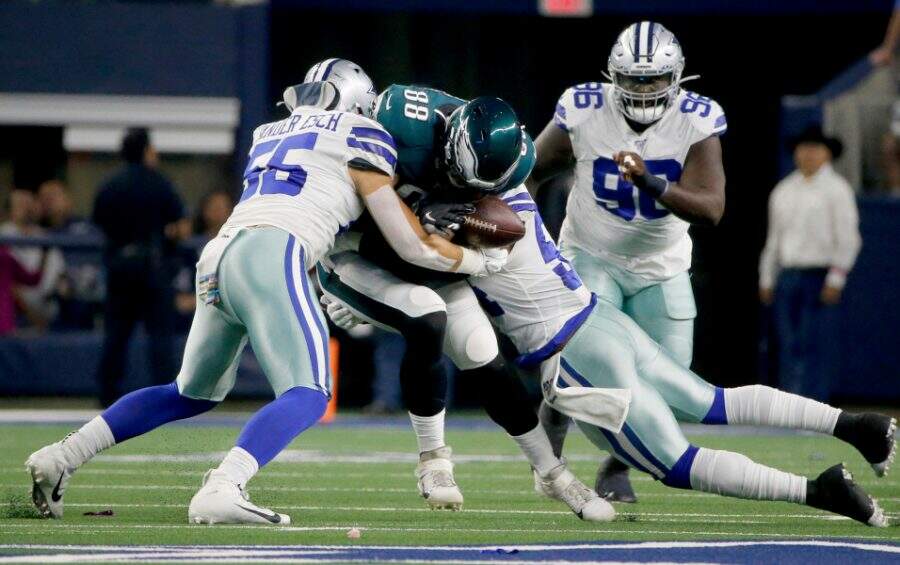 Dallas Cowboys' Leighton Vander Esch (55) and Jaylon Smith, right, tackle Philadelphia Eagles' Dallas Goedert (88) who fumbles the ball in the first half of an NFL football game in Arlington, Texas, Oct. 20, 2019. The Cowboys recovered the fumble. (AP Photo/Michael Ainsworth)