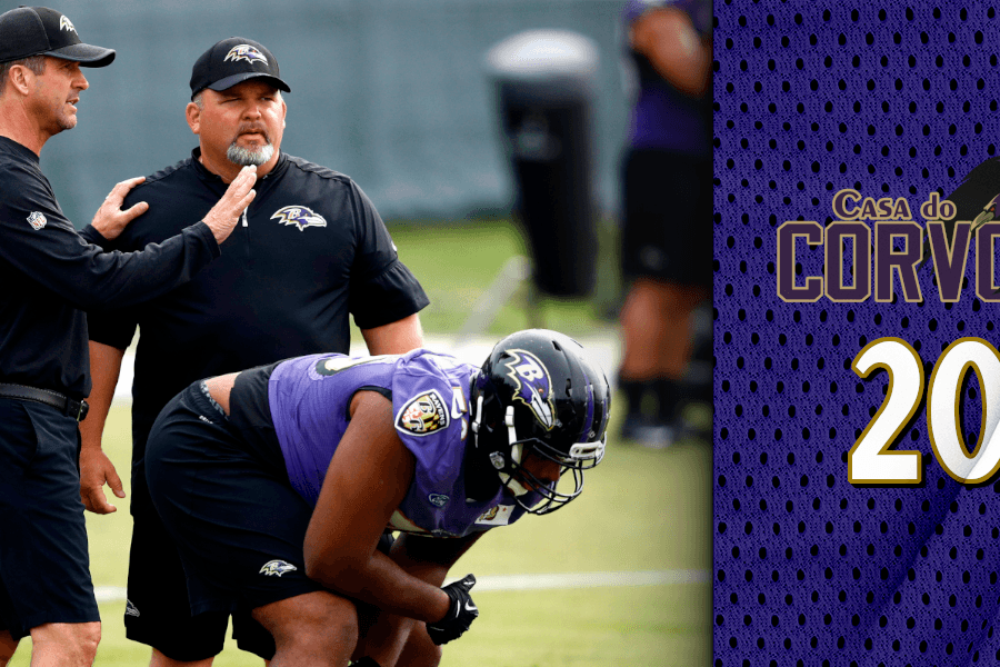 John Harbaugh e Greg Roman conversando me campo, enquanto ainda é coordenador ofensivo